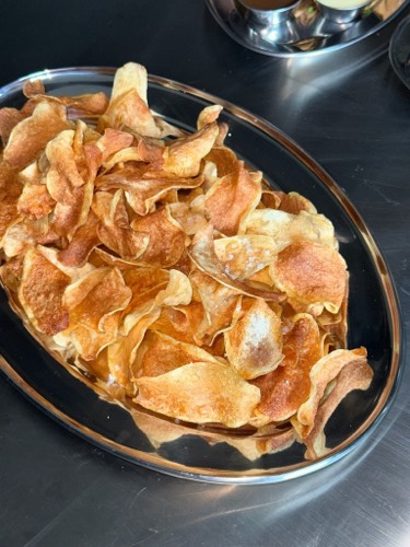 Kettle-cooked flat potato chips with sea salt and vinegar in a serving tray