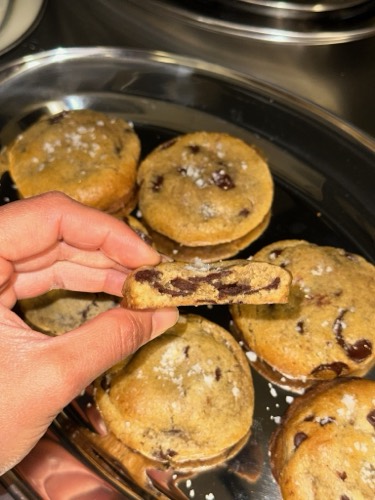 Chocolate chip cookie broken open to show a gooey Belgian dark chocolate center with Maldon sea salt