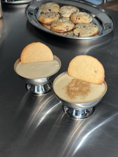 Roasted banana pudding with house baked vanilla wafers, served beside a chocolate chip cookie
